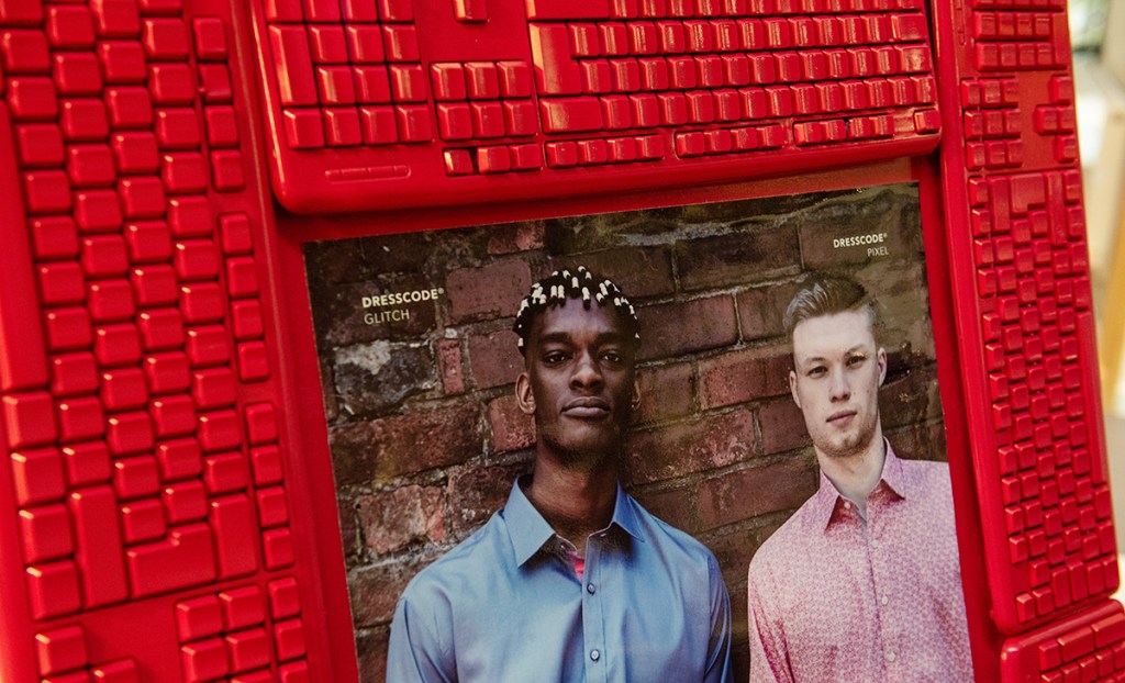 A photoframe made of computer keyboards, sprayed red with an image of 2 people wearing DressCode shirts. This was created for a pop-up event